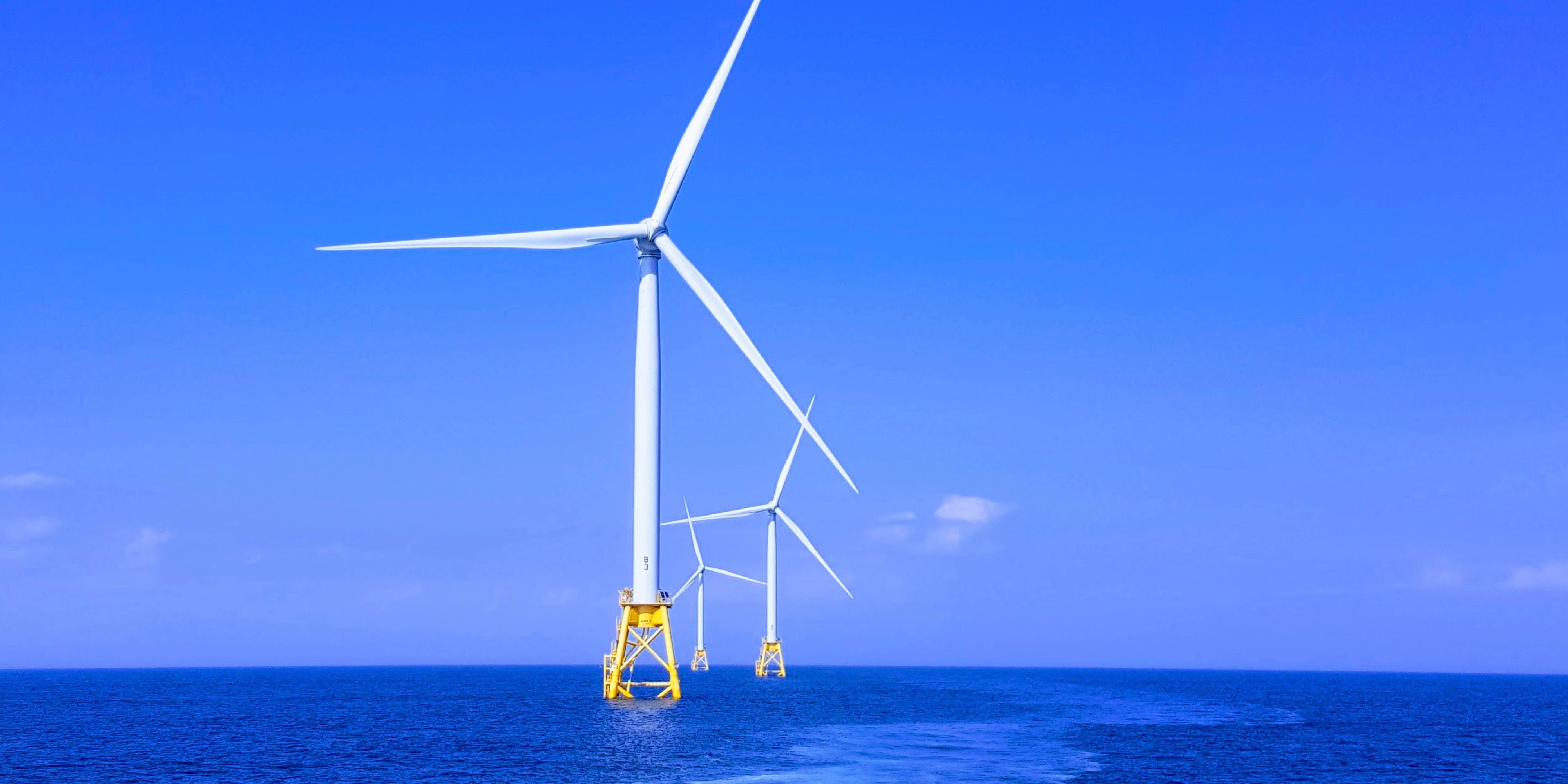 Offshore wind turbine set against a bright blue sky